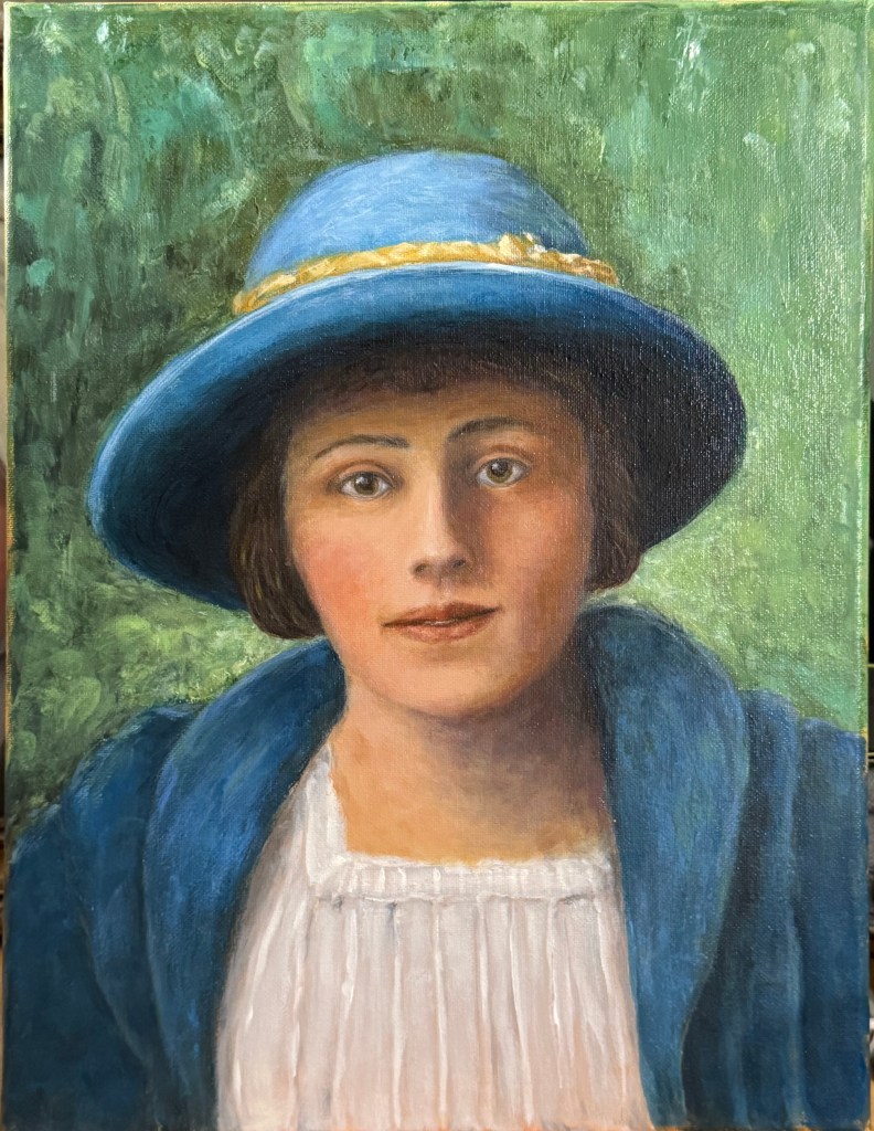 Young woman in a blue hat and blue coat with a mottled green background